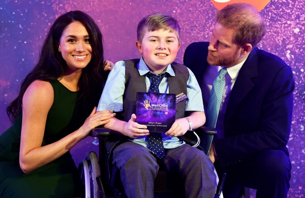 Britain's Prince Harry, Duke of Sussex, and Britain's Meghan, Duchess of Sussex pose for a photograph with award winner William Magee during the annual WellChild Awards in London on October 15, 2019. - WellChild is the national charity for seriously ill children and their families. The WellChild Awards celebrate the inspiring qualities of some of the country's seriously ill young people and the dedication of those who care for and support them. (Photo by TOBY MELVILLE / POOL / AFP) (Photo by TOBY MELVILLE/POOL/AFP via Getty Images) 